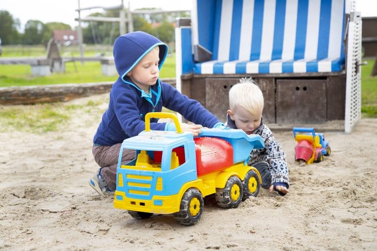 Zwei kleine Jungen spielen im Sandkasten.